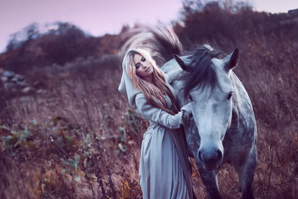 Loirinha de beleza com cavalo no campo, efeito de tonificação — Fotografia de Stock