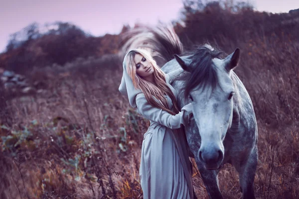 Belleza rubia con caballo en el campo, efecto de tonificación — Foto de Stock