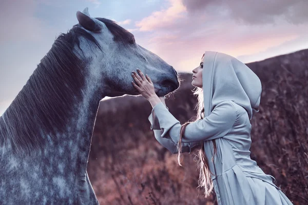 Piękna blondie z konia w polu, efekt tonowania — Zdjęcie stockowe