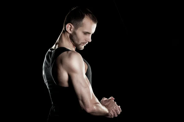 Muskulöser Mann, Hände in der Faust, schwarzer Hintergrund, rechts Platz für Text — Stockfoto