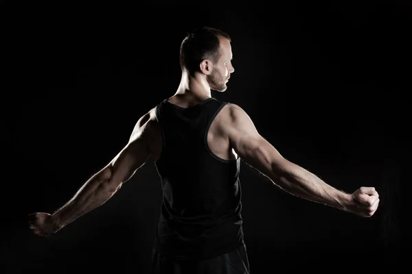 Muscular man,  black background, place for text on the right — Stock Photo, Image