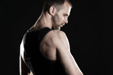 kaslı adam, tokalar eller yumruk, siyah arka plan, metin sağda yer