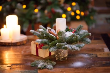 Fir branches decorated for the new year on dark wooden background. Christmas tree and candles, festive mood
