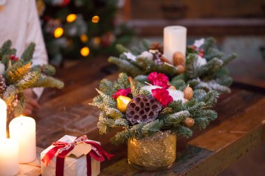 Fir branches decorated for the new year on dark wooden background. Christmas tree and candles, festive mood