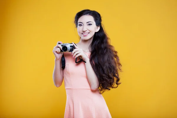 Moda asiática jovem fotógrafo com câmera, retrato sobre fundo amarelo — Fotografia de Stock