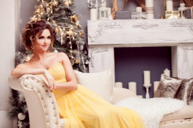 Noel ağacı ışıkları arka plan üzerinde gülümseyen kadın gece elbisesi içinde