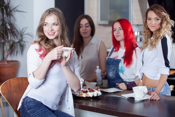 Друзі п'ють чай і каву на кухні, портрет молодої красивої брюнетки на передньому плані, жінки з білою чашкою — стокове фото