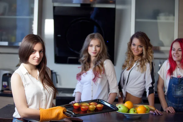 Chica con magdalenas horneadas en su cocina, hermosa mujer joven sale de muffins horno — Foto de Stock