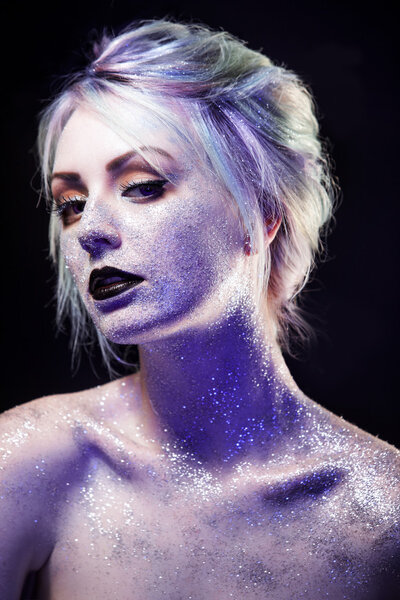 Unusual girl with bright fashion makeup, creative body art on theme space and stars.