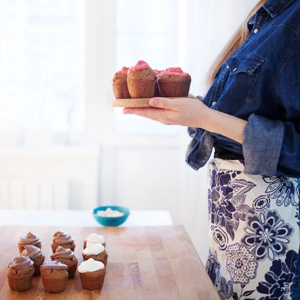 Mädchen hält Teller mit frischen heißen Muffins, verschwommener Hintergrund — Stockfoto