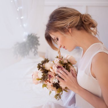 taze günlük makyaj ve romantik dalgalı saç modeli, elinde bir buket çiçek ile güzel bir kadın modeli
