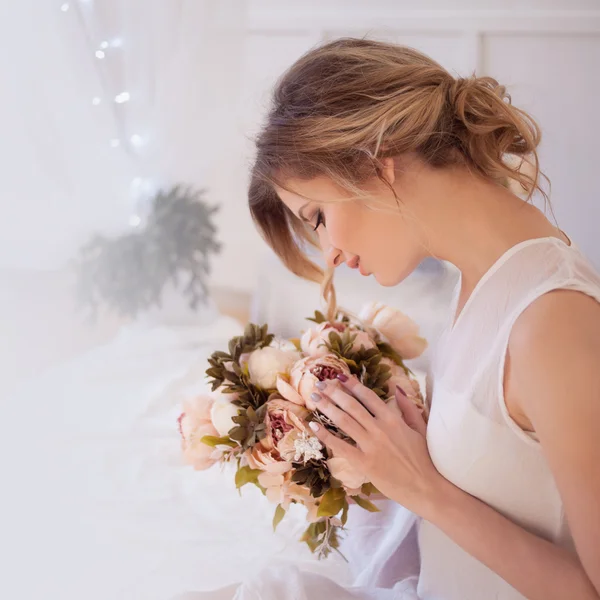 Modelo mulher bonita com maquiagem diária fresca e penteado ondulado romântico, segurando um buquê de flores — Fotografia de Stock