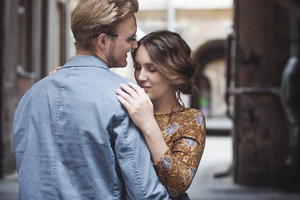 Jeune couple amoureux en plein air. L'homme embrasse la femme. La fille regarde par-dessus l'épaule d'un partenaire — Photo