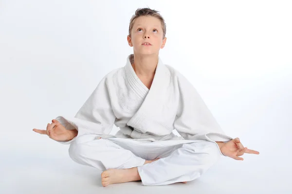 Медитирующий мальчик-каратист — стоковое фото