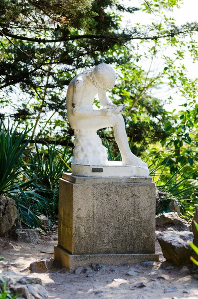 Junge, der einen Splitter herauszieht. Skulptur. — Stockfoto