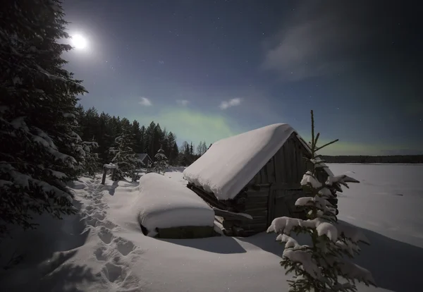 Dorpshuis in het licht van de maan en de Aurora borealis. Noord-Karelia. Rusland. — Stockfoto