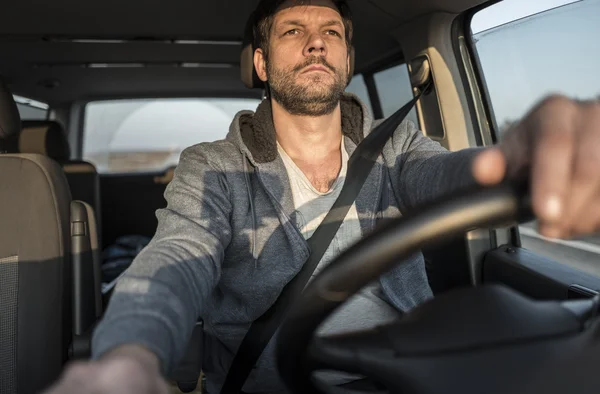 Tired unshaven man is driving the car — Stock Photo, Image