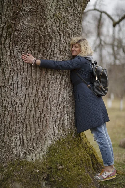 Güzel sarışın kız ağaç sarılma