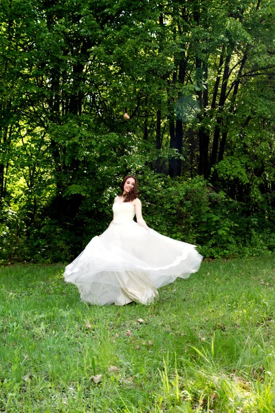 Noiva bonita e feliz virou em uma clareira florestal — Fotografia de Stock