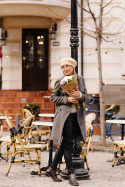 Bereli güzel bir kadın portresi ve bir buket çiçekli bardaklar.