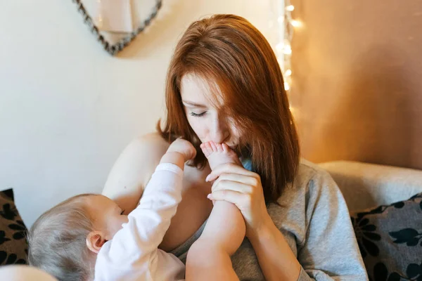 Little Girl Lies Her Mother Arms Mother Kisses Baby Leg — Stock Photo, Image