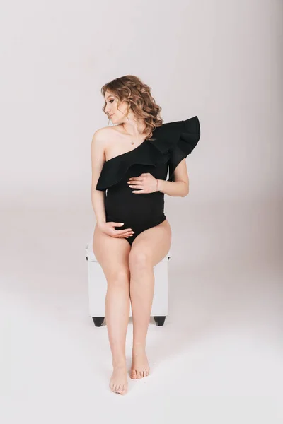 Schwangere Hält Studio Ihren Bauch Sanft Auf Grauem Hintergrund — Stockfoto