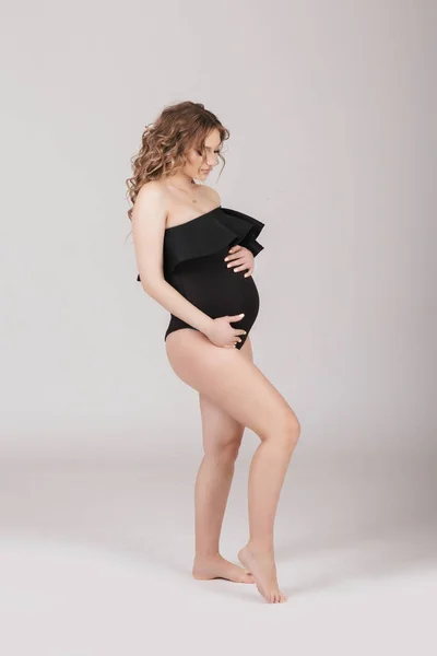 Schwangere Steht Und Umarmt Zärtlich Ihren Bauch Studioshooting — Stockfoto