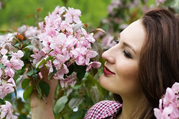 Woman by flowers on tree — Stock Photo, Image
