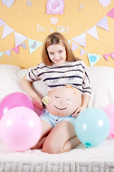 Schwangere mit aufgemaltem Gesicht auf Bauchschläfer — Stockfoto