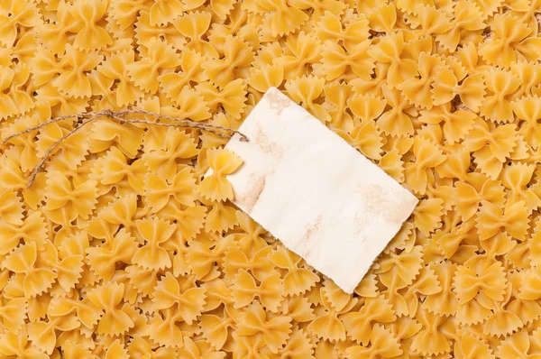 Old empty paper on raw pasta — Stock Photo, Image