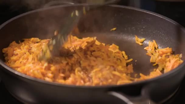 Frying onions and carrots on pan — Stock Video