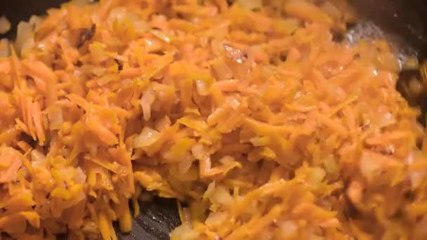 Жареный лук и морковь на сковороде — стоковое видео