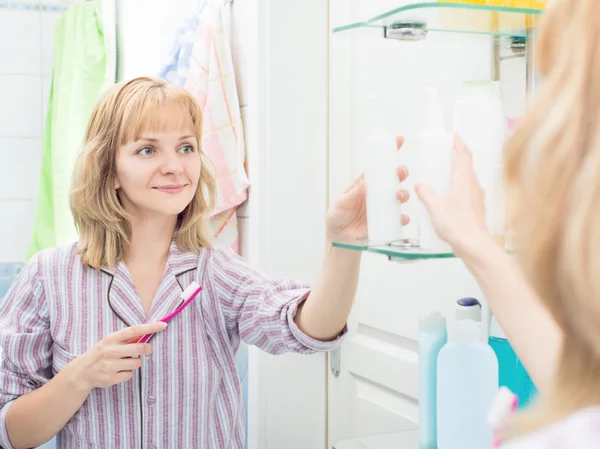Mulher escovando dentes no banheiro — Fotografia de Stock