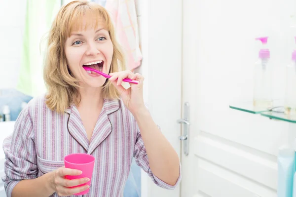 Vrouw poetsen tanden in badkamer — Stockfoto