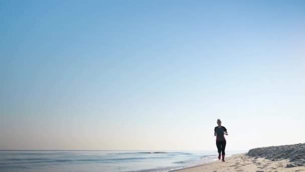 La mujer corre en la playa del mar — Vídeos de Stock
