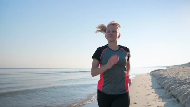 Kobieta biegnie po plaży morskiej — Wideo stockowe