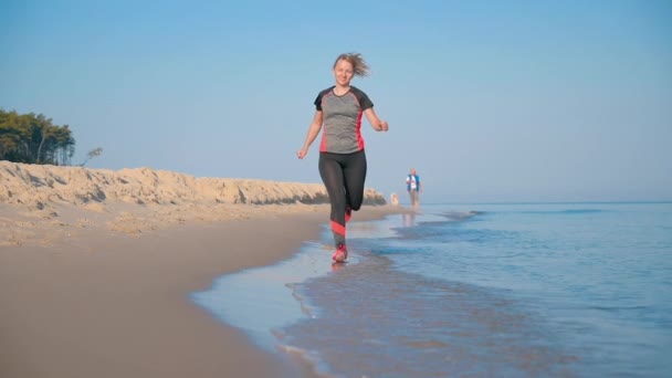 Женщина бегает по морскому пляжу — стоковое видео