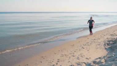 Kadın deniz sahilinde koşuyor.