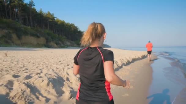 Жінка біжить на морському пляжі — стокове відео