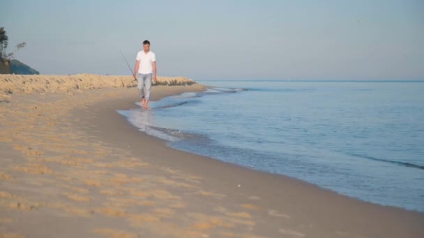 Man with fishing rod on beach — Stock Video