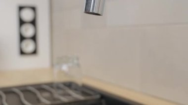 Adam bir bardak su dolduruyor.