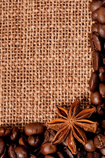 Granos de café con especias en saco de arpillera — Foto de Stock