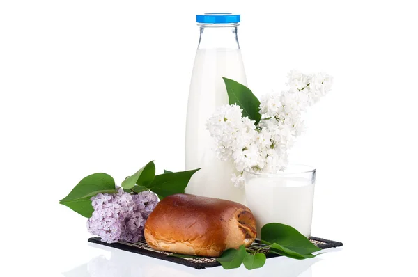 Bouteille de lait avec branche lilas et pain — Photo