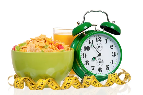 Big green alarm clock with breakfast — Stock Photo, Image