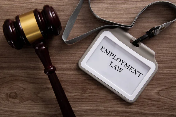 Gavel and a employee card written with Employment Law on wooden background.