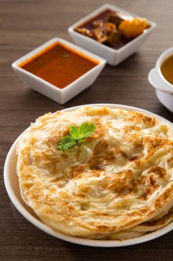 Roti Parata or Roti canai with lamb curry sauce - popular Malaysian breakfast clipart