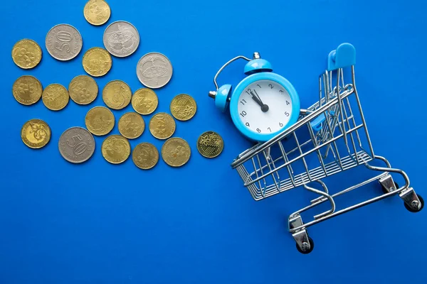 Tijd Geld Winkeltijd Supermarkttrolley Met Klok Munten Blauwe Achtergrond — Stockfoto