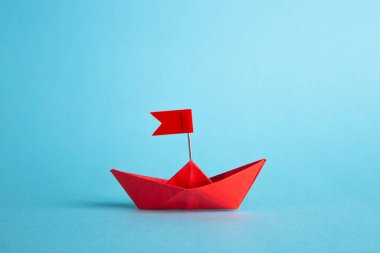 Liderlik kavramı. Kırmızı lider kağıt gemi mavi arka planda diğerleri arasında lider.
