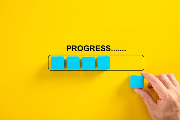 Hand putting wooden cube on virtual infographic rectangleblock with progress wording. Job progressive concept.