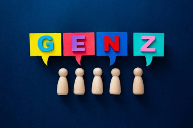 Renkli konuşma baloncuklarının altında duran tahta insan figürleri Z jenerasyonunu oluşturuyor.